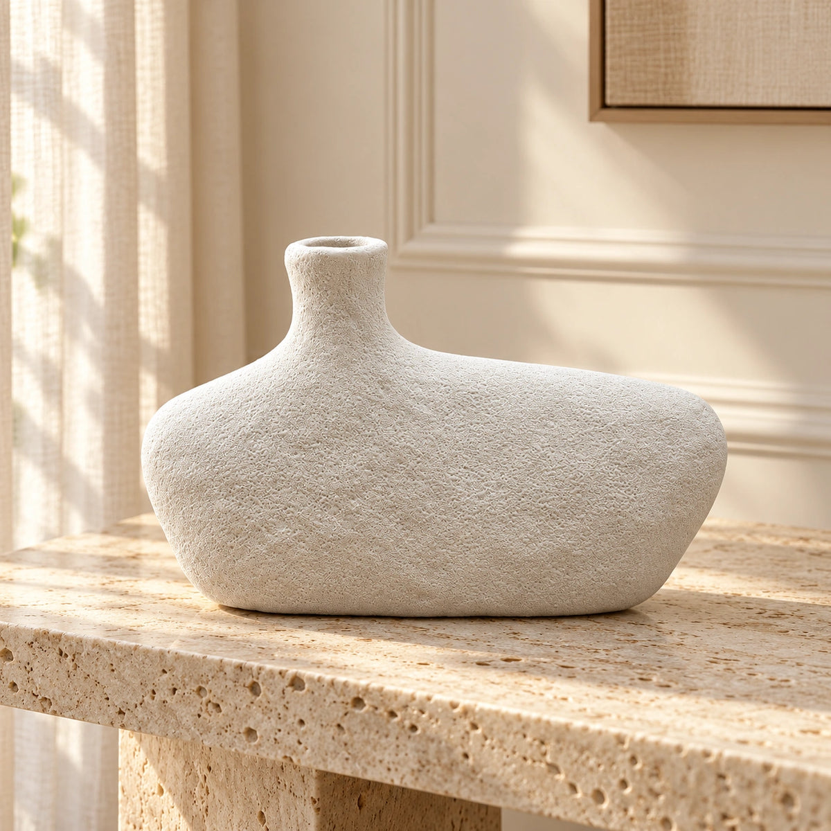 Off-white textured asymmetric pebble decor vase, styled on a travertine console