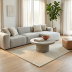 Modern living room with a gray sectional sofa, round wooden coffee table, and a plant.