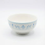 White ceramic bowl with blue floral patterns on a white background