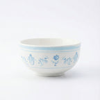 White ceramic bowl with blue floral patterns on a white background