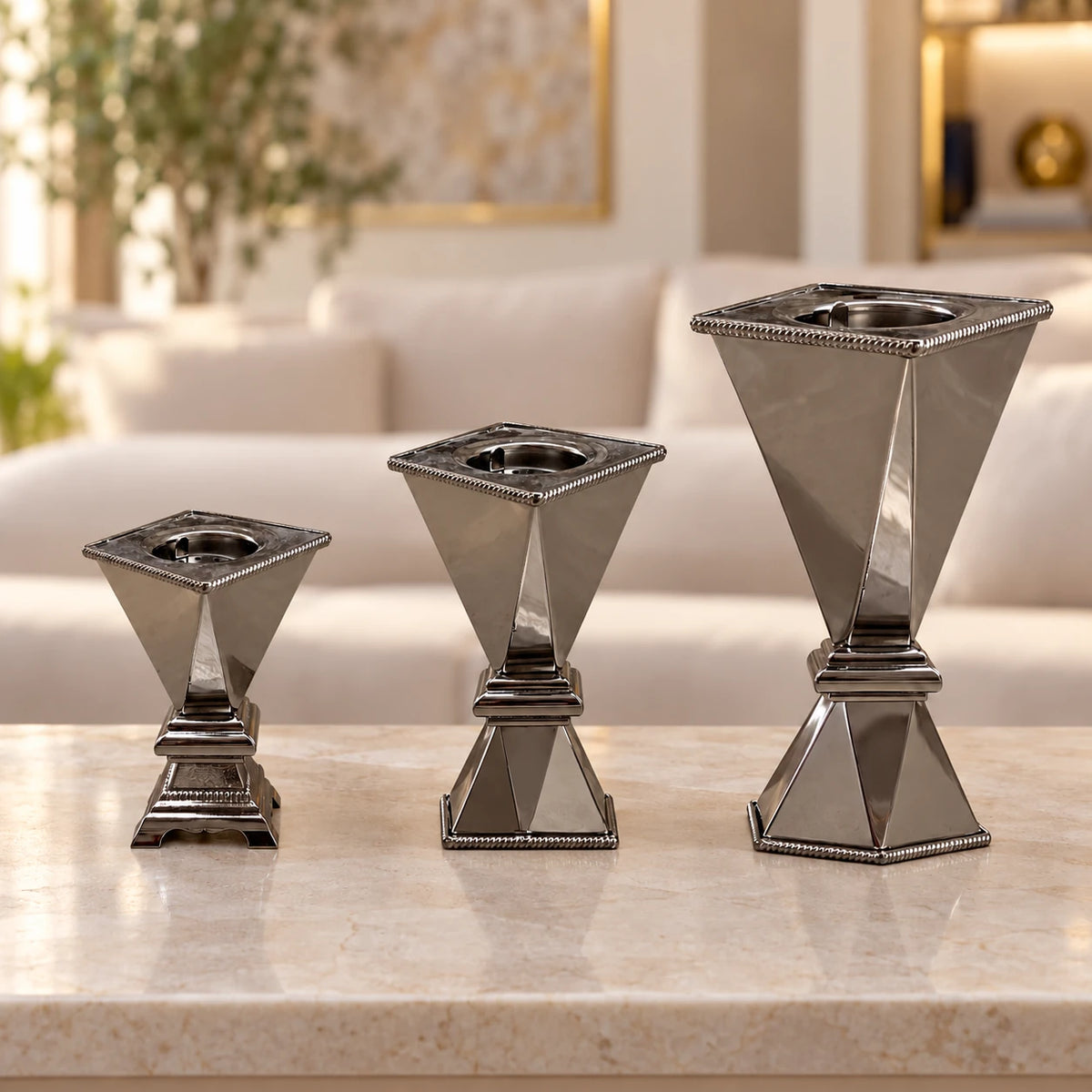 Silver-tone bakhoor incense burners in 20 cm, 25 cm and 35 cm heights displayed together on a stone console